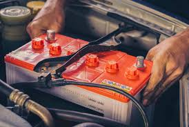 Imagem de uma pessoa usando um testador de bateria em um carro