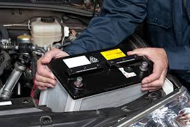 Imagem de um mecânico instalando uma bateria de carro